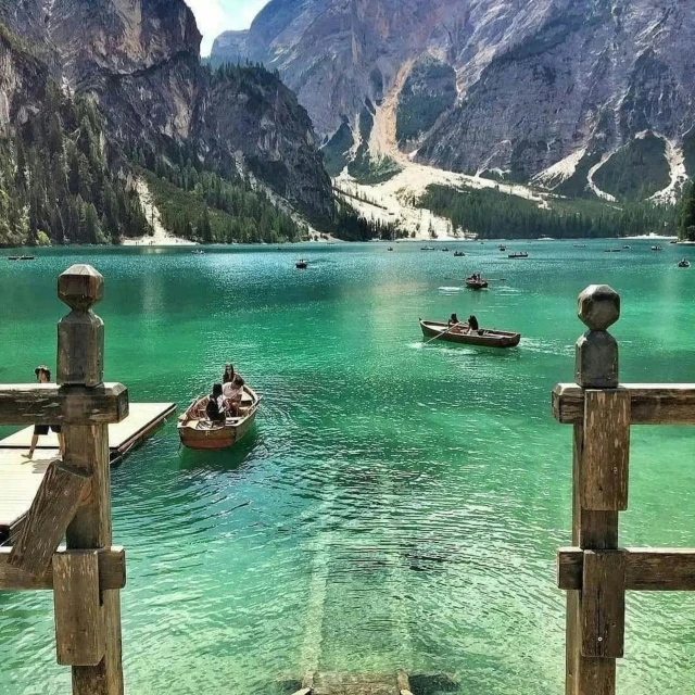 several small boats are floating on a lake