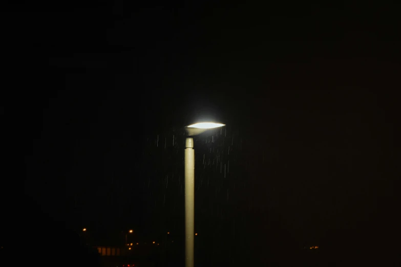a light in the dark on top of a pole