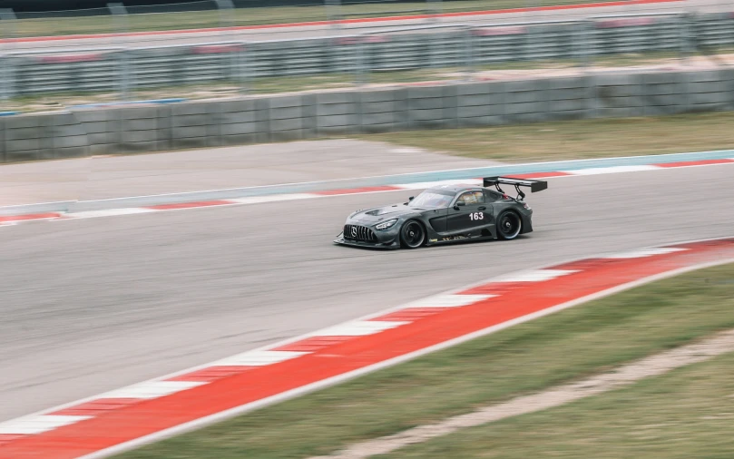 a car driving on a track near grass