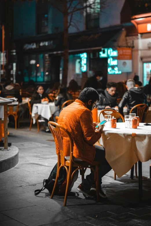 a person sitting at an outside table with some drinks