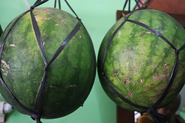 two watermelons, each wrapped in black ribbon and sitting on a chair