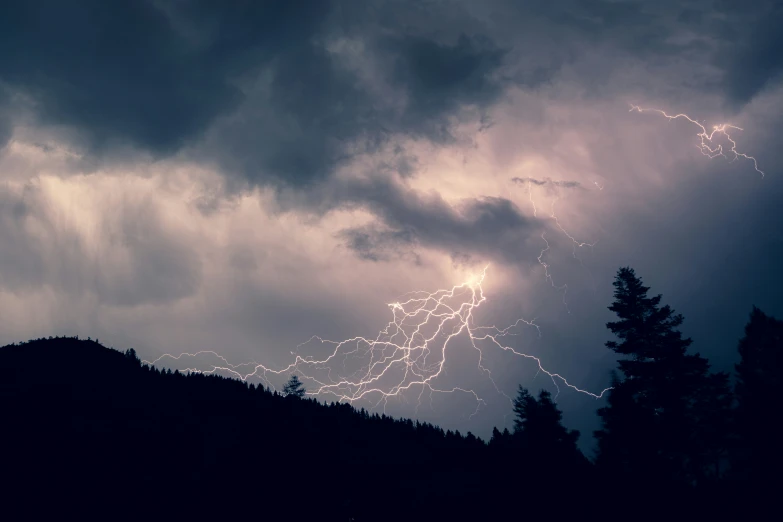 a view of a mountain side during a lightning storm