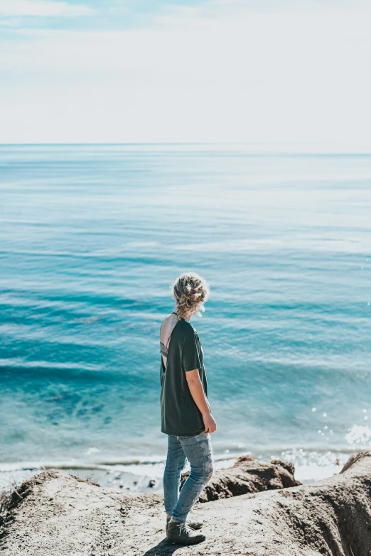 a man standing on top of a beach next to the ocean