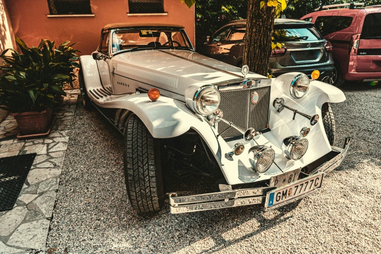 there is a old fashioned car on the street