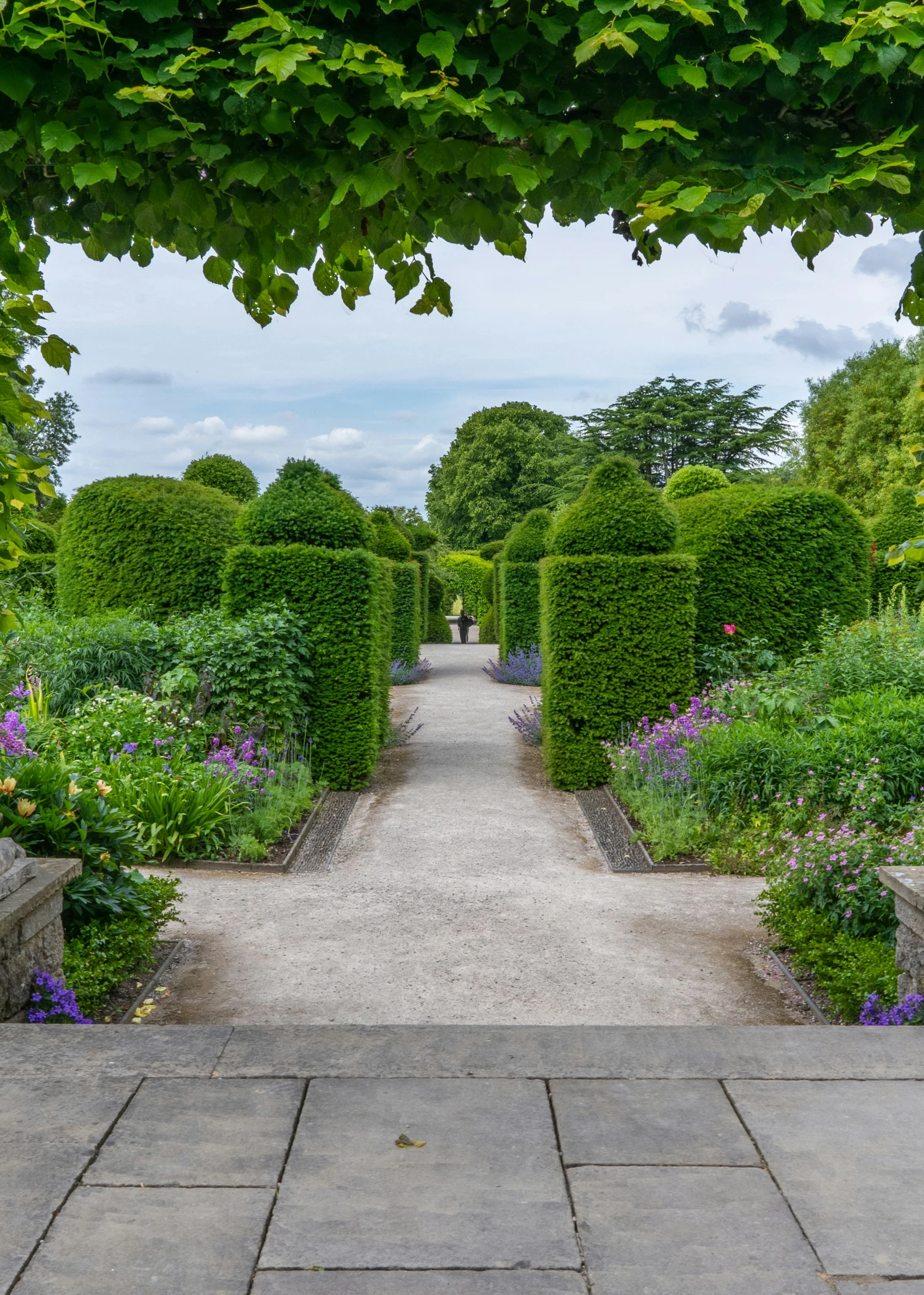 an empty walkway leads into a walled garden