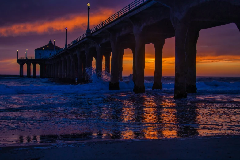 there is a long pier next to the ocean at twilight