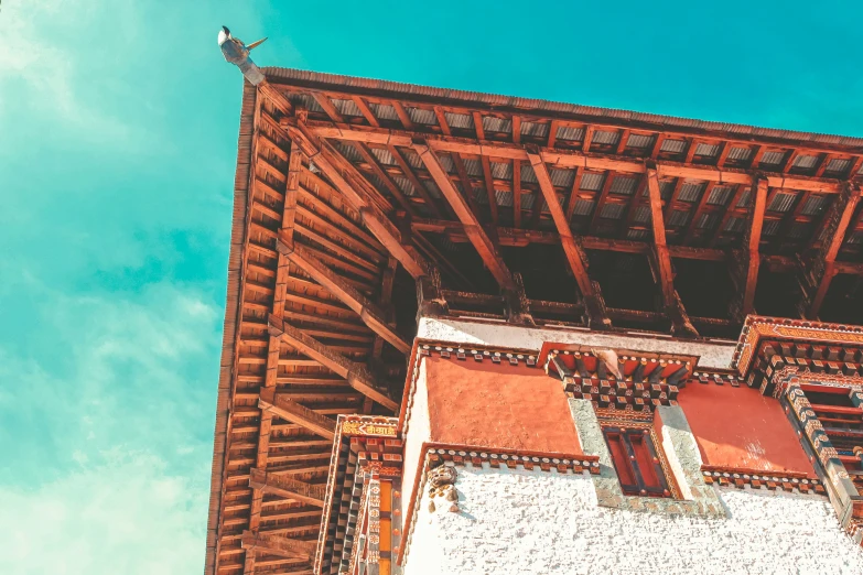 a bird perches on a roof that has wooden beams