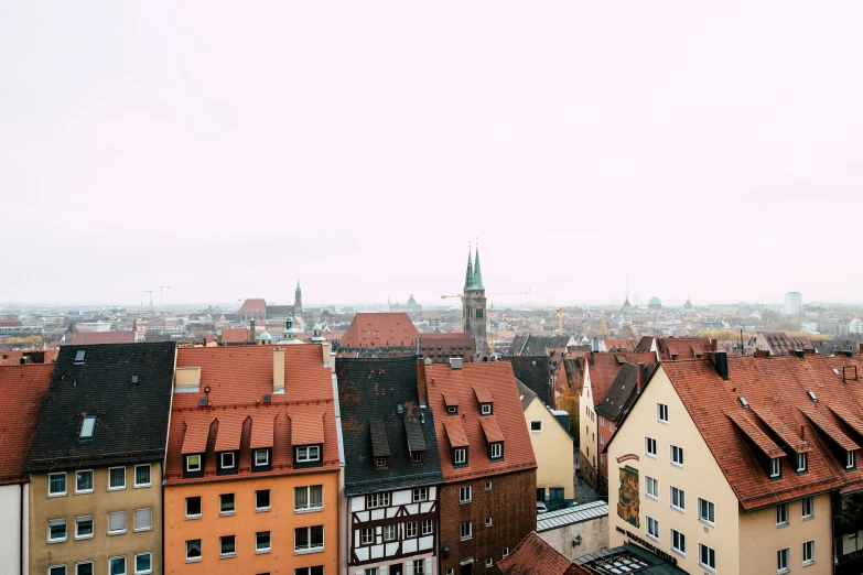 the view from the tower of a church shows the city's red roofs