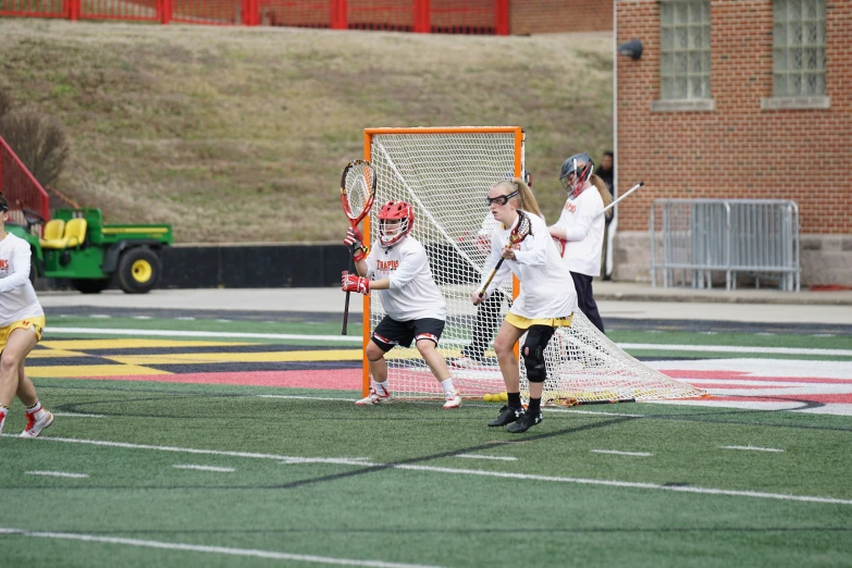 group of people playing a game of lacrosse on field