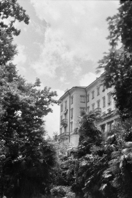 a large building sits near trees and a pond