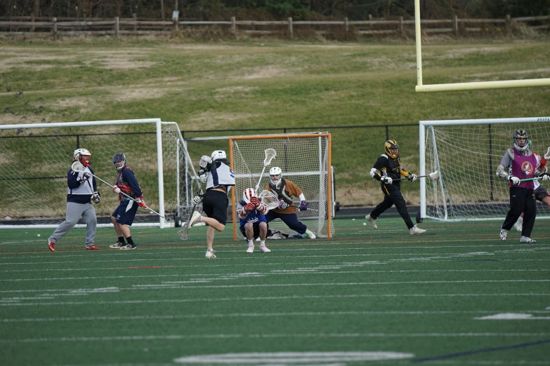 several young lacrosse players playing a game in the field