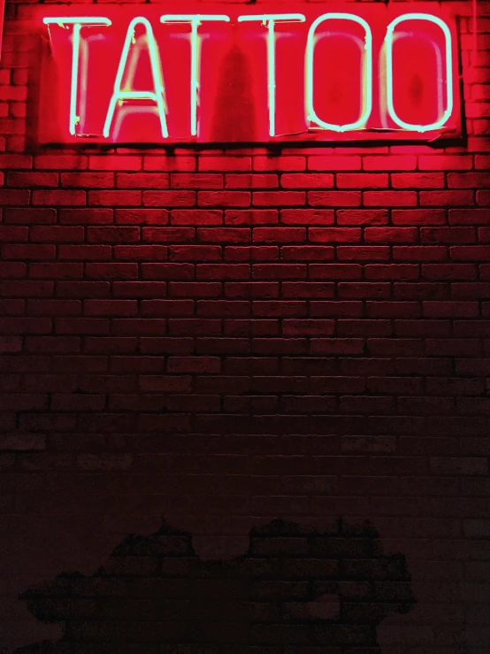 red tattoo sign on wall of brick building