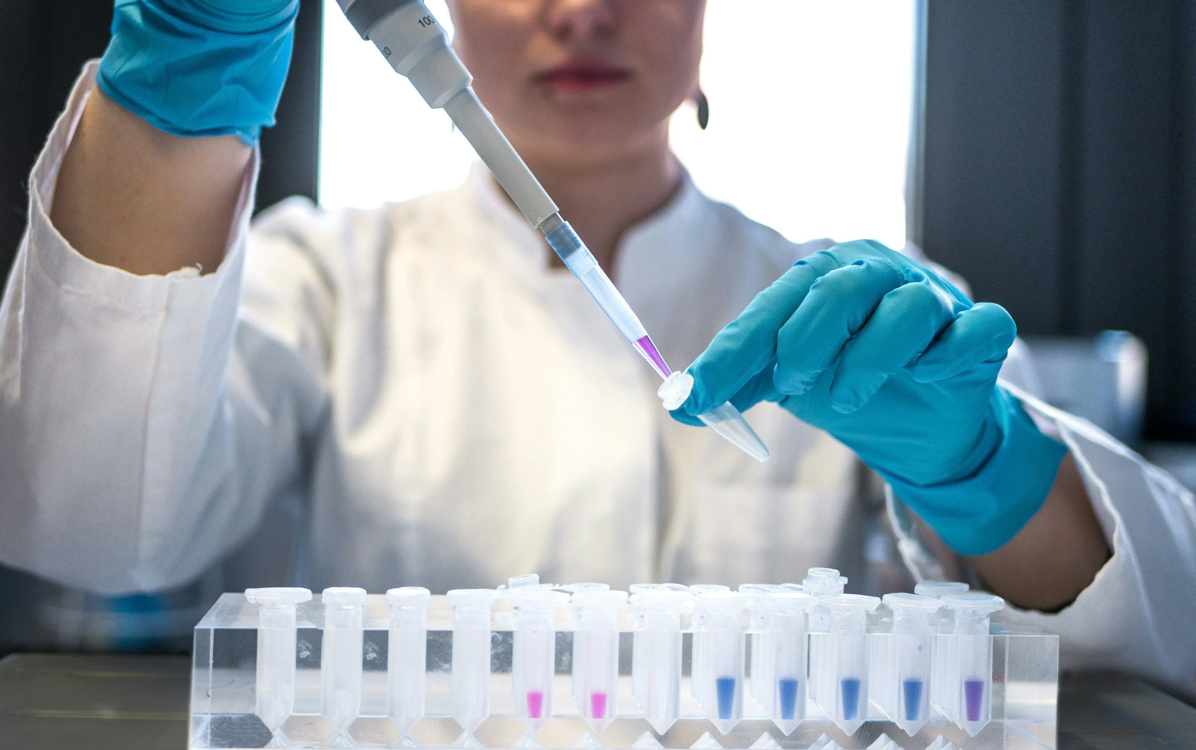 an asian woman in white coat holding up a tube