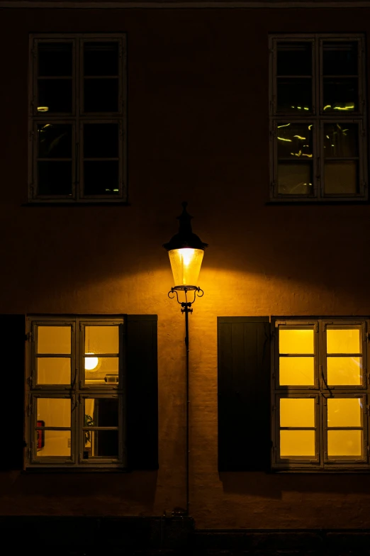 a lamp shines brightly on an old building with windows