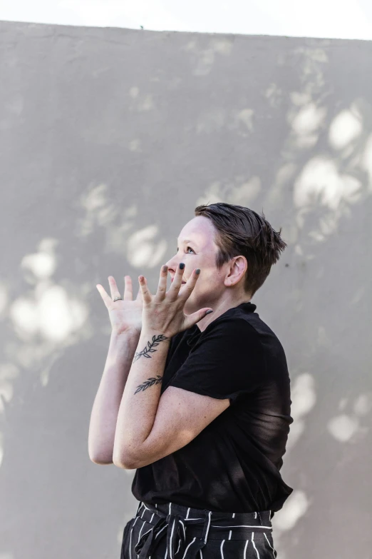 a woman in a black shirt is standing outside and looking up