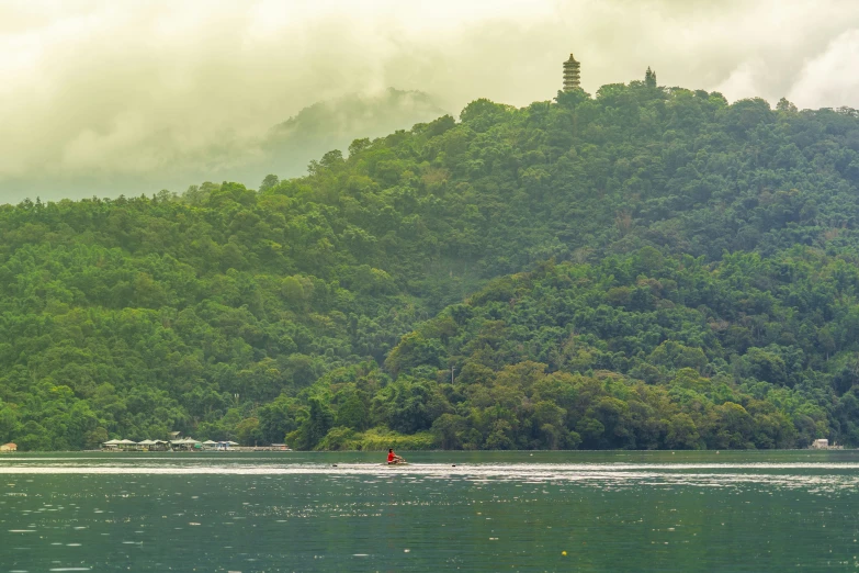 a boat floating through the water by some mountains