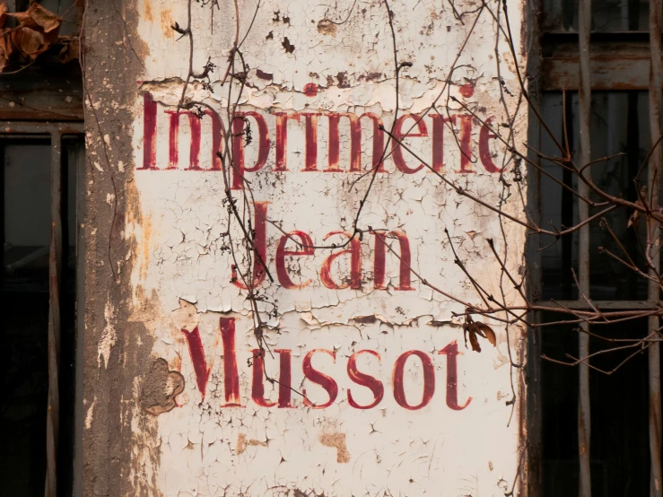 a rusted sign sitting next to a window