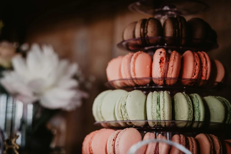 a tower that has various flavored macarons on it