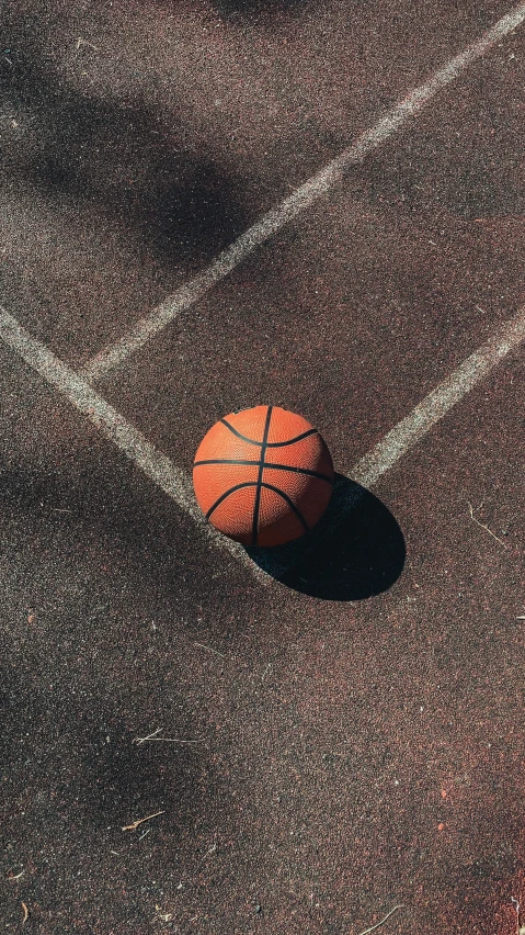 a basketball is on the ground in the middle of a basketball court