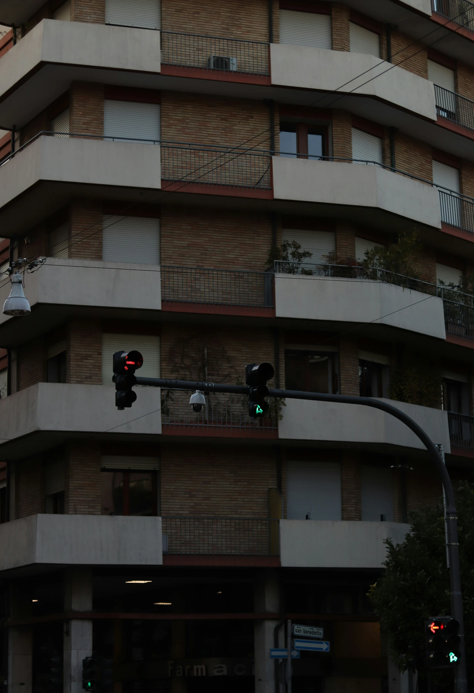 an urban building with balconies and stop lights