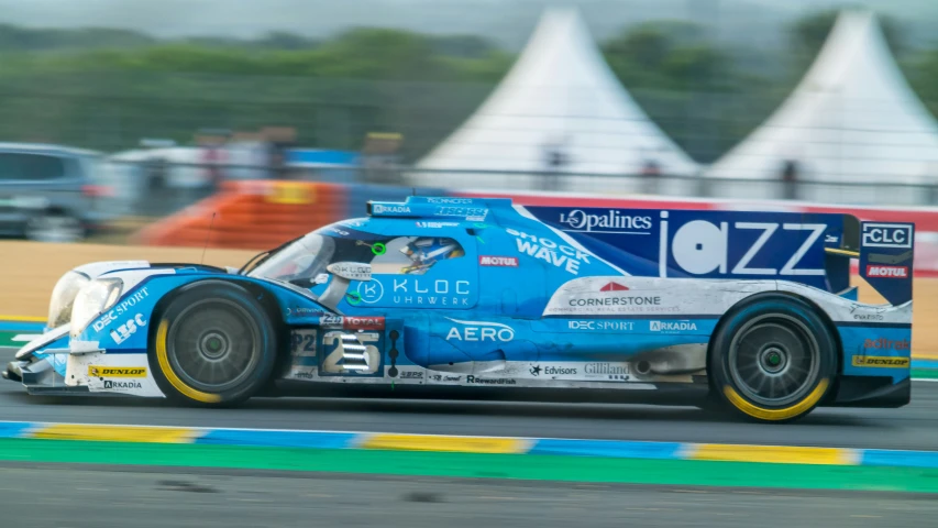 a blue race car speeds around a track