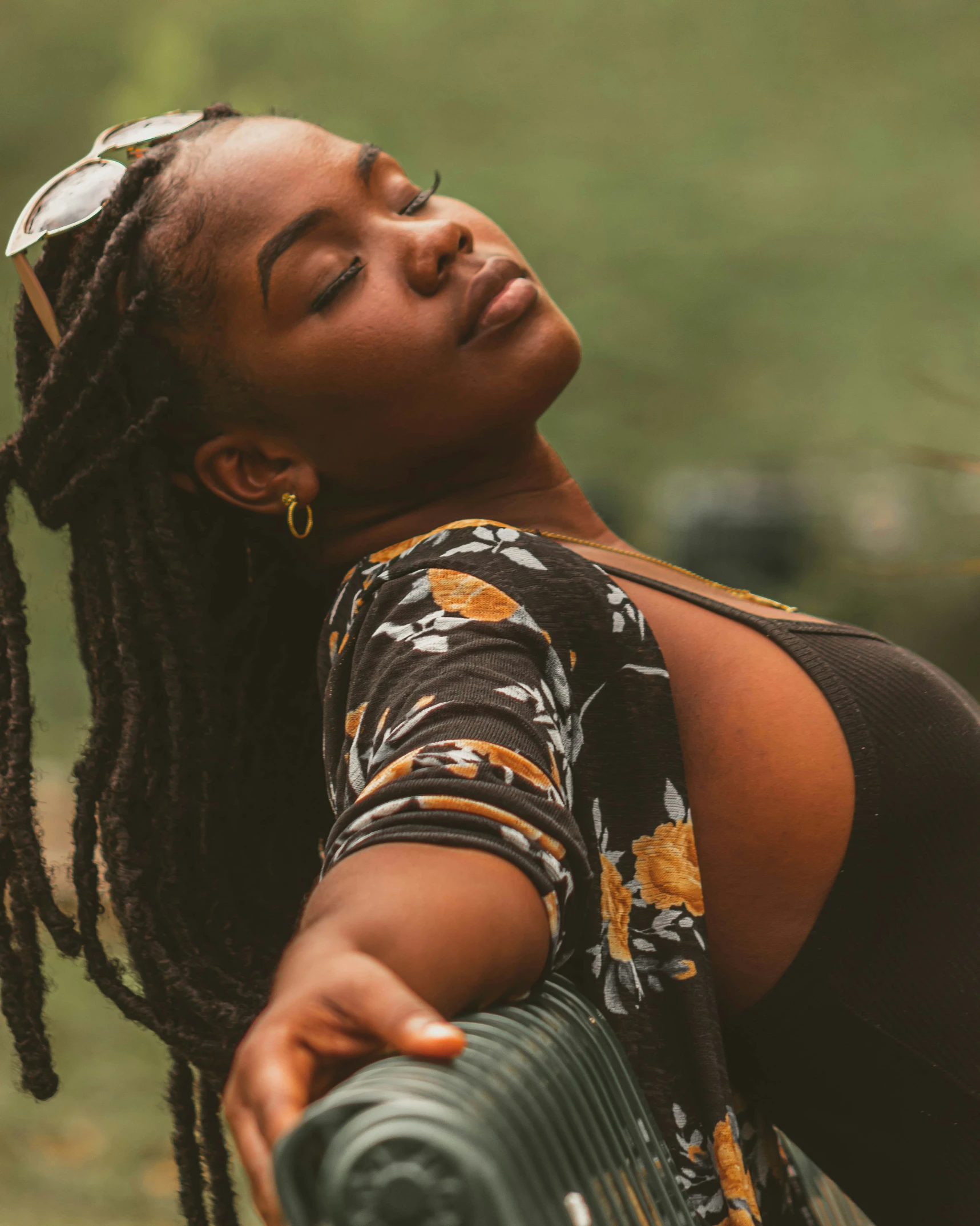 a woman with dreadlocks holds her hand out to the sky