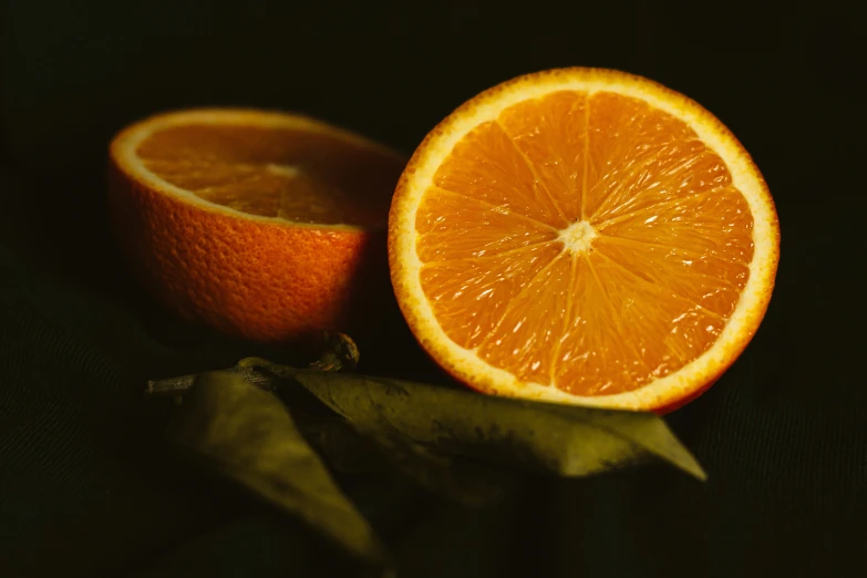 an orange is cut into pieces on a black surface