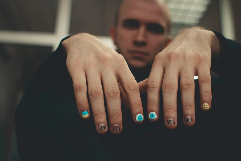 a person sitting down with a manicured hand with two fingers on top of each other