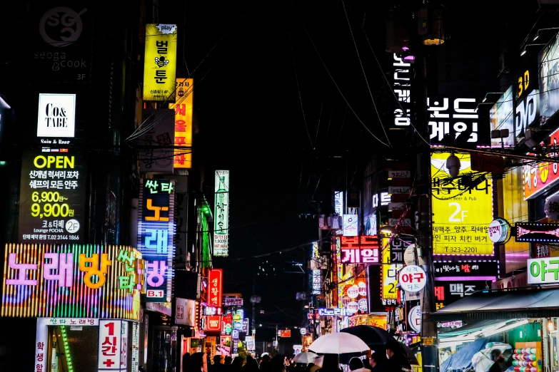 some people on street with lights signs buildings and umbrella