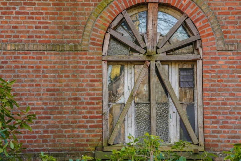 an old window on a building with a wooden wheel