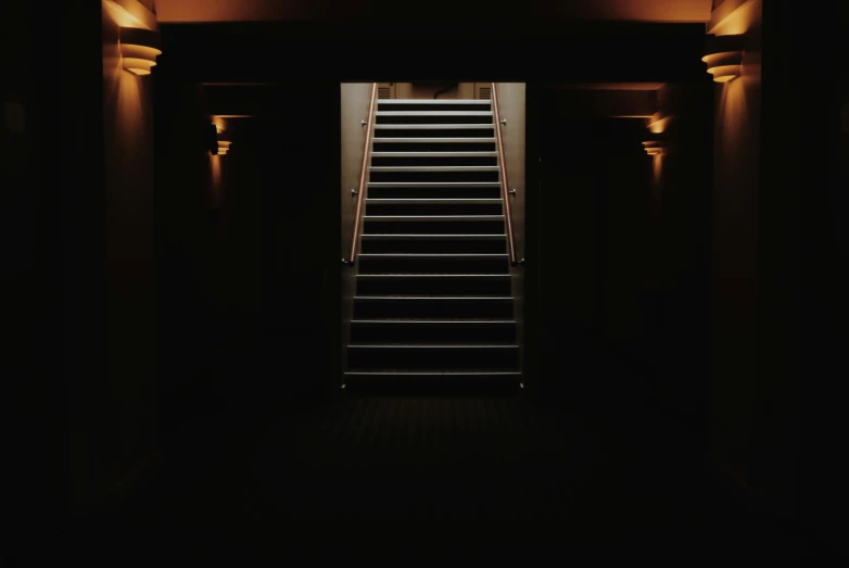 a stair case leading into the distance, in a dark room