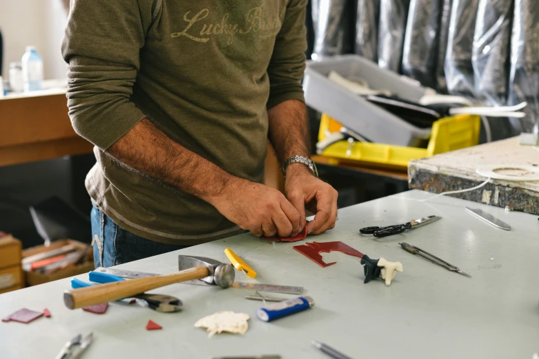 a man working with tools at a sewing shop