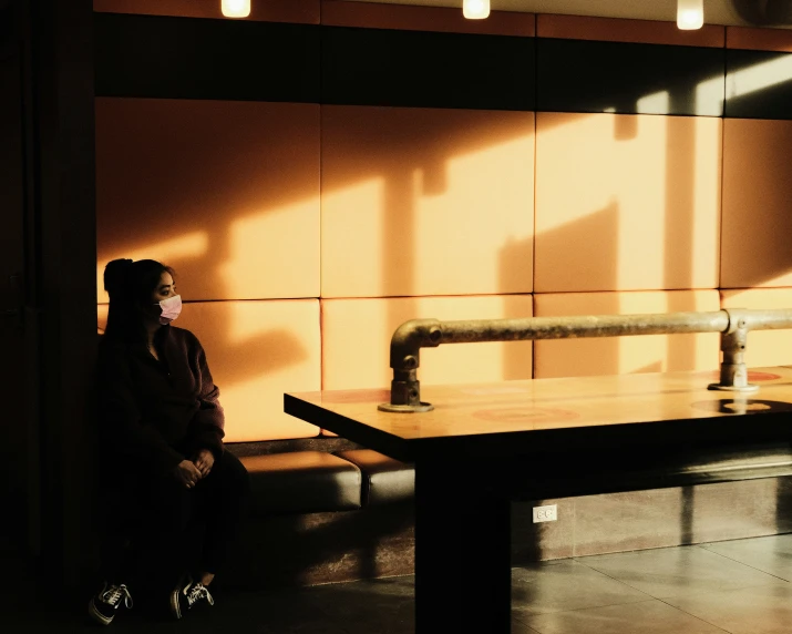 a woman standing in a room with a table in the middle of the room