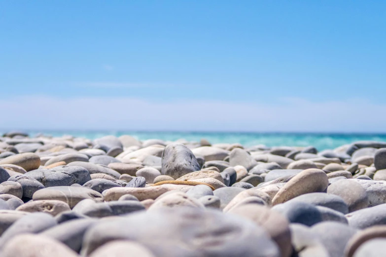 rocks on the sand and the water as seen from behind