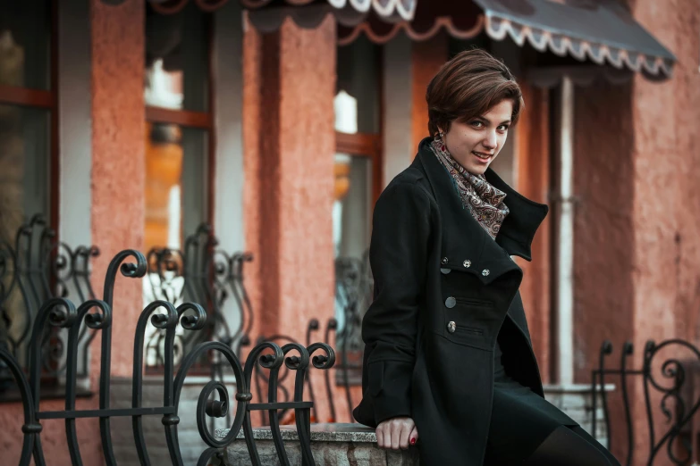 a woman is standing on a wall outside