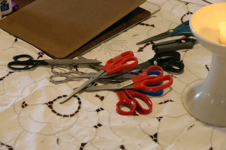 five pairs of scissors are laying on a table cloth