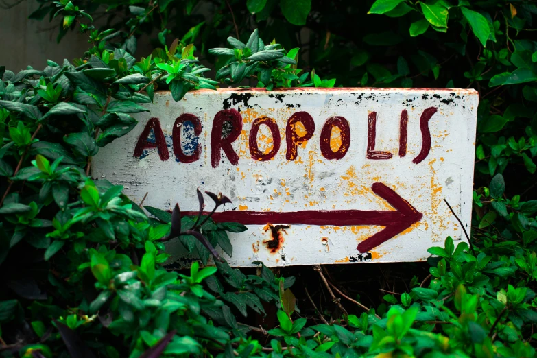 an arrow is painted on an old white sign