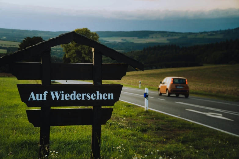 sign with name attached to wooden post on highway