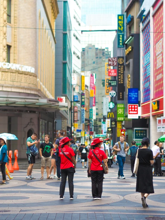 three people are walking on the street in the rain