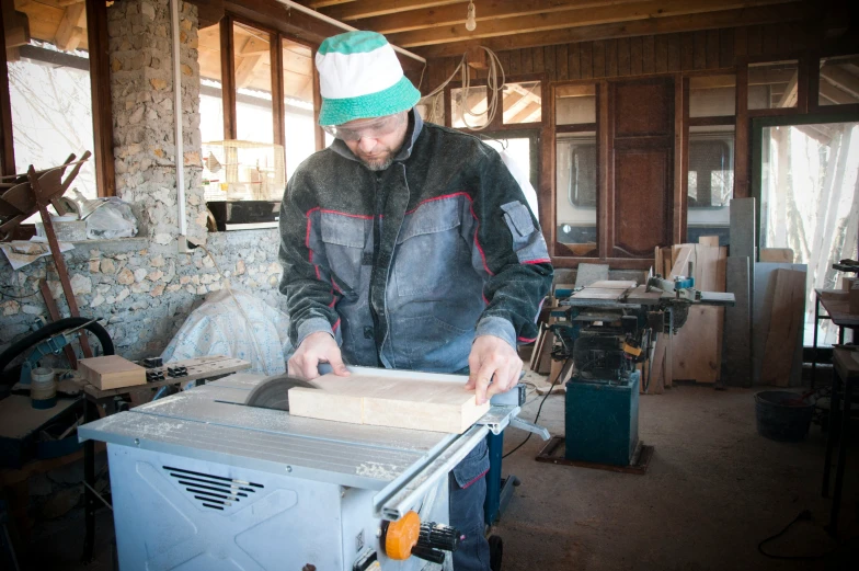 man making box from old paper inside of house