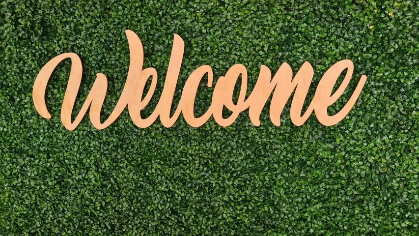 a close up of a wooden welcome sign