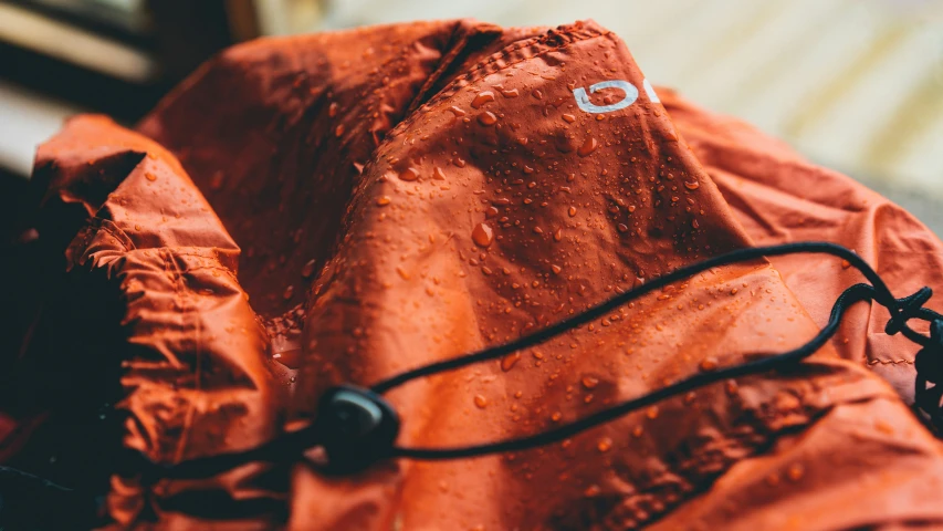 a close - up s of an orange coat with a logo on it