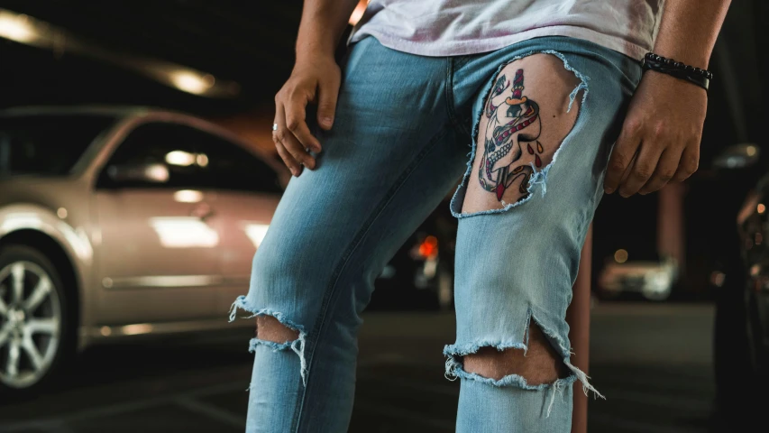 the ripped legs and leg of a person with tattoos