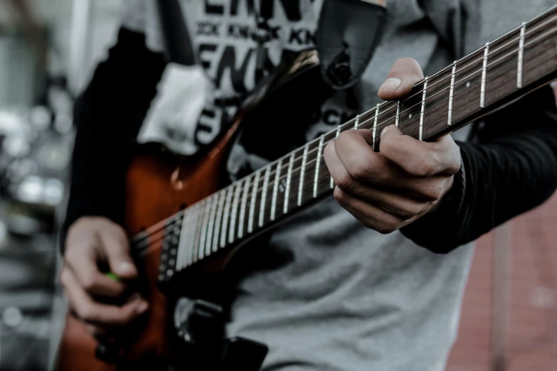 a man holding an electric guitar while playing it