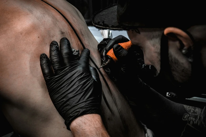 a person with gloves on leaning against a wall