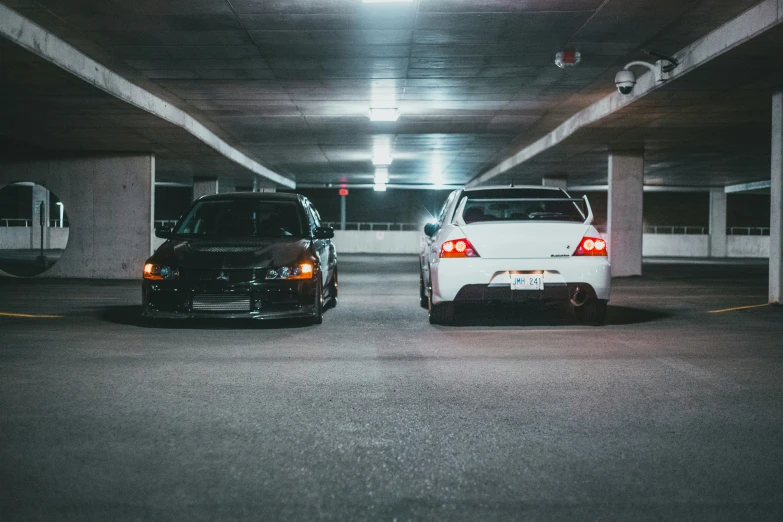 a couple of parked cars sitting inside of a parking lot