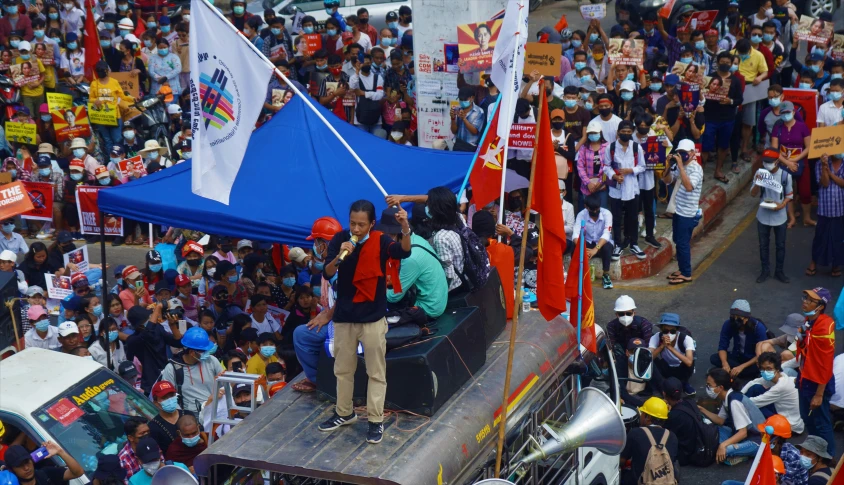 the parade floats over a parade route while many hold flags and banners