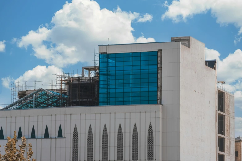 a modern building with scaffolding on top in front of a blue sky