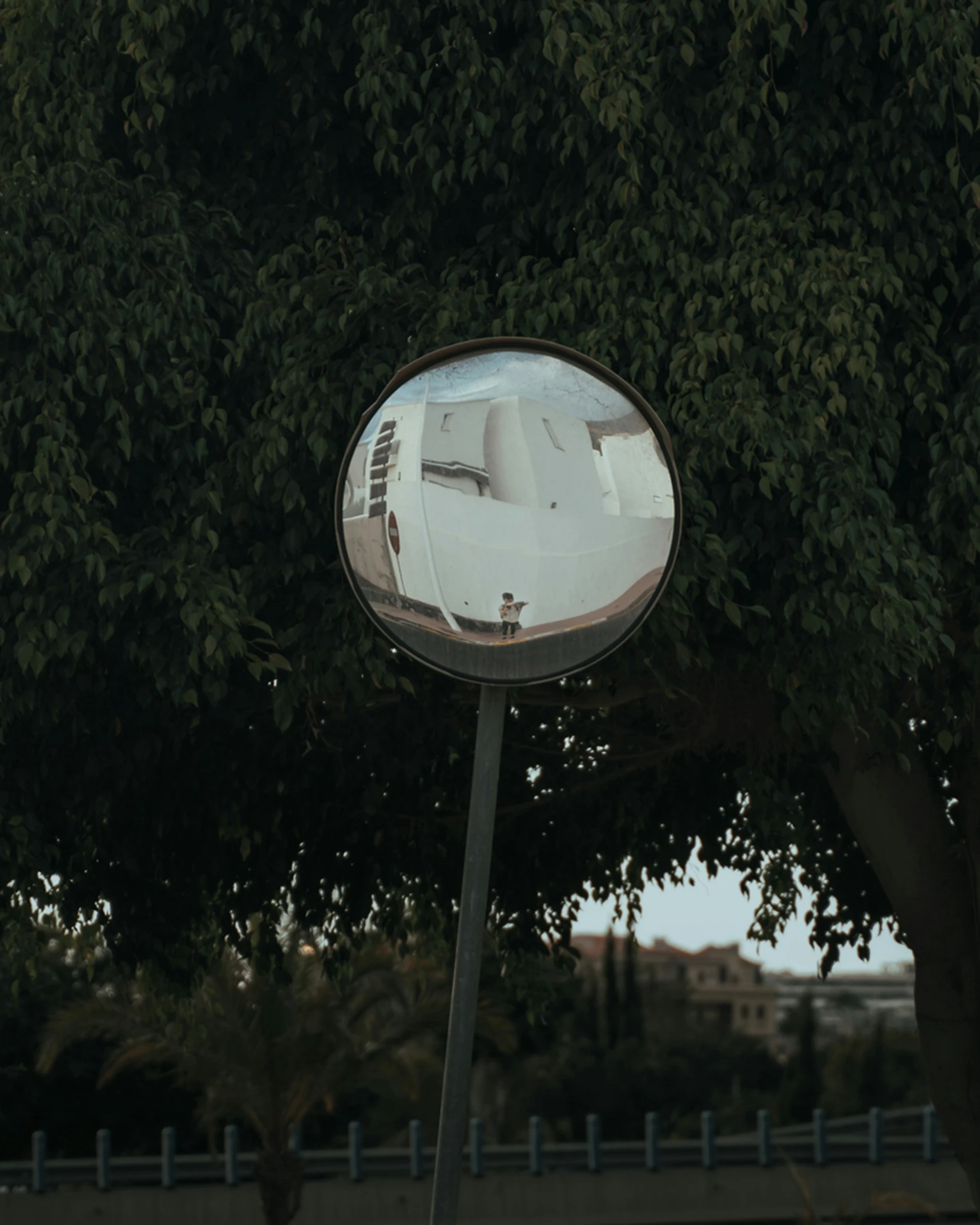 a street mirror reflects a reflection of an image on it