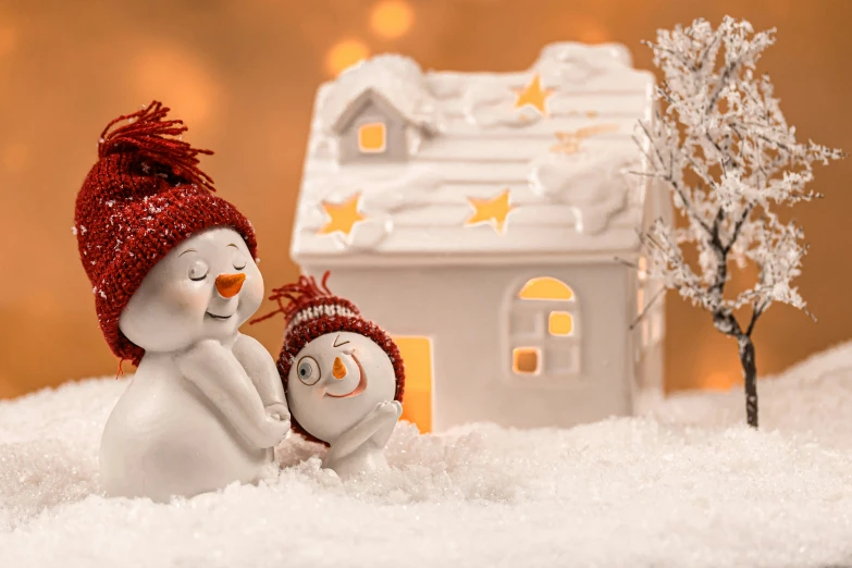 a snowman next to a toy house in the snow